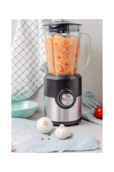 blender full of food being puréed. garlic heads on counter, empty bowl