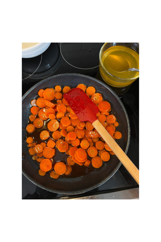 frying pan with sliced carrots and spatula